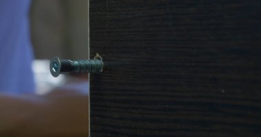 Bir elektrikli el matkabı bir Pano bir vida sürücü kullanan adam. Ortamda bulunan toz tanecikleri Parlatıcı havadaki toz. Vida sıkma