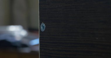 Bir elektrikli el matkabı bir Pano bir vida sürücü kullanan adam. Ortamda bulunan toz tanecikleri Parlatıcı havadaki toz. Vida sıkma