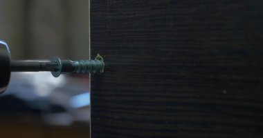 Bir elektrikli el matkabı bir Pano bir vida sürücü kullanan adam. Ortamda bulunan toz tanecikleri Parlatıcı havadaki toz. Vida sıkma