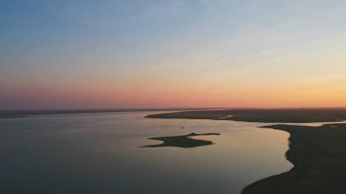 Kuşlar sürüsü renkli gökyüzü arka plan üzerinde. Günbatımı Nehri üzerinde. Martı Adası. Günbatımında hava Kuşlar uçar