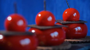 Bisküvi ve çikolata ile üç kırmızı pasta. Arka plan koyu mavi kırmızı lezzetli kek