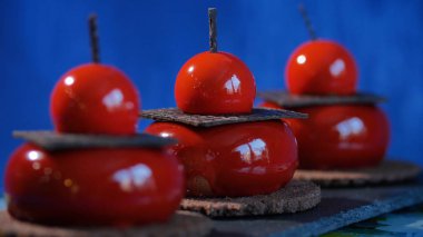 Bisküvi ve çikolata ile üç kırmızı pasta. Arka plan koyu mavi kırmızı lezzetli kek