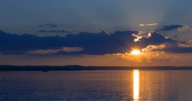 Gün batımı göl üzerinde. bulutlar. Su. Gökyüzünde San.