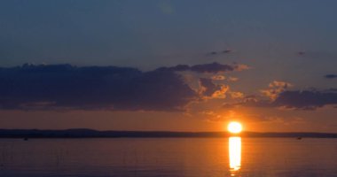 Gün batımı göl üzerinde. bulutlar. Su. Gökyüzünde San.