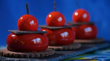 Bisküvi ve çikolata ile üç kırmızı pasta. Arka plan koyu mavi kırmızı lezzetli kek