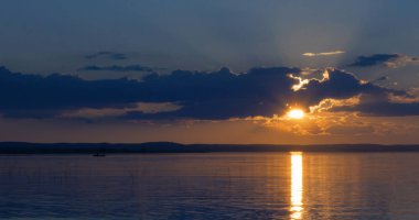 Gün batımı göl üzerinde. bulutlar. Su. Gökyüzünde San.