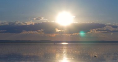 Gün batımı göl üzerinde. bulutlar. Su. Gökyüzünde San.
