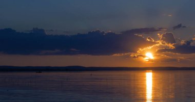 Gün batımı göl üzerinde. bulutlar. Su. Gökyüzünde San.