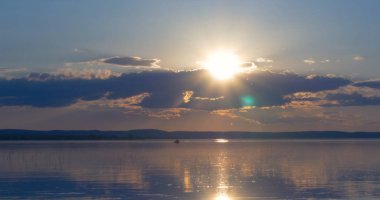 Gün batımı göl üzerinde. bulutlar. Su. Gökyüzünde San.