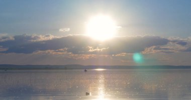 Gün batımı göl üzerinde. bulutlar. Su. Gökyüzünde San.