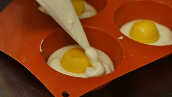 Pastry bag filling a flexible silicone mold with mousse. Gourmet French dessert, close-up — Stock Photo, Image