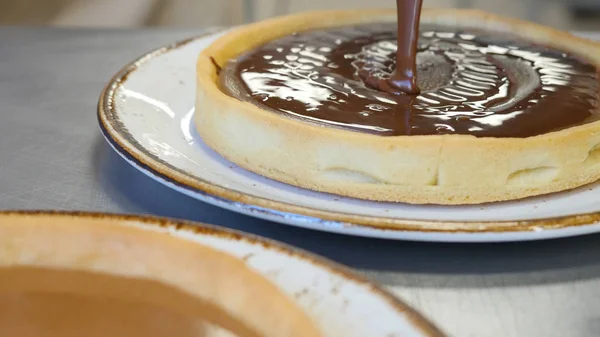 Chocolate derramando em pedaço de deliciosos bolos recém-assados — Fotografia de Stock