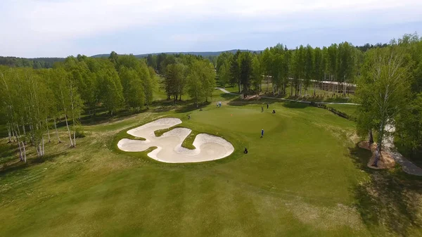 Aerial view of golfers playing on putting green. Professional players on a green golf course — Stock Photo, Image