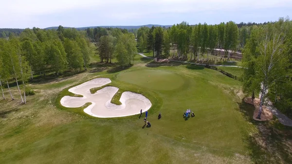 Veduta aerea dei golfisti che giocano a putting green. Giocatori professionisti su un campo da golf verde . — Foto Stock
