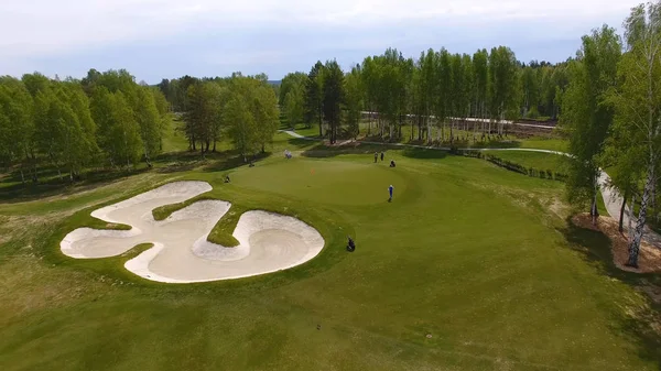 Havadan görünümü üzerinde yeşil koyarak oynamaya golfçüler. Yeşil bir golf profesyonel oyuncular