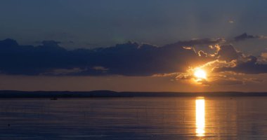 Gün batımı göl üzerinde. bulutlar. Su. Gökyüzünde San.