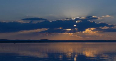 Gün batımı göl üzerinde. bulutlar. Su. Gökyüzünde San.