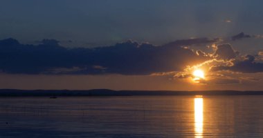 Gün batımı göl üzerinde. bulutlar. Su. Gökyüzünde San.