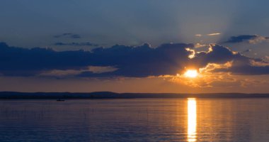 Gün batımı göl üzerinde. bulutlar. Su. Gökyüzünde San.