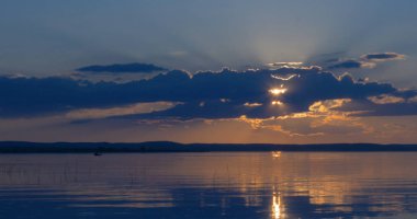 Gün batımı göl üzerinde. bulutlar. Su. Gökyüzünde San.