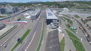 Formula 1 parça Sochi, Sochi Olimpiyat Köyü. Şantiye Stadyumu yakın kasaba ve dağlar yarış yaz güneşli gün için. Havadan görünümü. Pectator Aerrial görünümünde F1 Rus standları