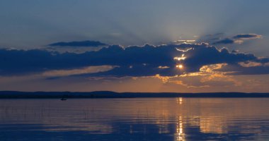 Gün batımı göl üzerinde. bulutlar. Su. Gökyüzünde San.