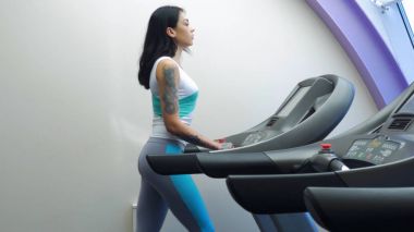 Spor egzersiz, koşu bandı üzerinde çalışan aktif genç kadın. Bir makinede çalıştırın. Spor salonunda makine üzerinde çalışan genç sportif kadın. Bir kadın bir koşu bandı üzerinde koşu.