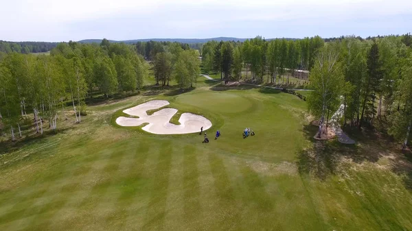 Havadan görünümü üzerinde yeşil koyarak oynamaya golfçüler. Yeşil bir golf profesyonel oyuncular.