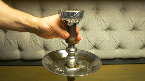 Humo de narguile sobre un fondo negro con un hermoso humo. Tazón de narguile marrón para tabaco con pierna larga. Preparación de la shisha, aka nargile o hookah en un restaurante colocando los carbones en la parte superior . — Foto de Stock