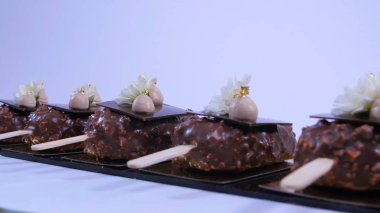Dondurma, çikolata ile kaplı. Çikolatalı dondurma bir sopa. Çikolatalı dondurma çiçeklerle süslenmiş bir sopa