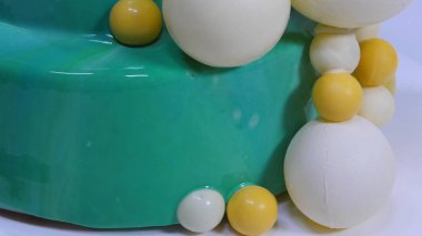 Turkuaz ayna sır ile şık mousse kek. Turkuaz ayna sır ile pasta çikolata topları ile dekore edilmiştir.