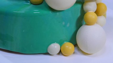 Turkuaz ayna sır ile şık mousse kek. Turkuaz ayna sır ile pasta çikolata topları ile dekore edilmiştir.