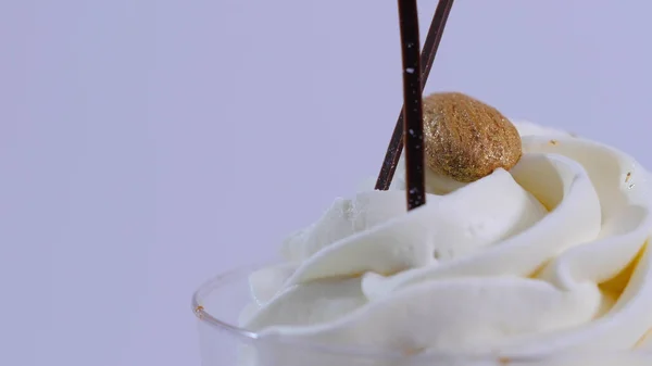 Sorvete de baunilha sundae na xícara no fundo. Sorvete em um copo com creme, close-up — Fotografia de Stock