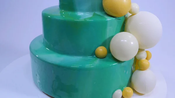 Gâteau en mousse élégant avec glaçure miroir turquoise. Gâteau avec glaçure miroir turquoise décoré de boules de chocolat — Photo