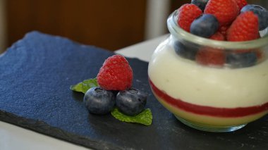 Ev yapımı yoğurt bir cam kavanoza yaban mersini ile. güzel meyveleri tatlı süslemeleri, yakın çekim için düzenlenmiş
