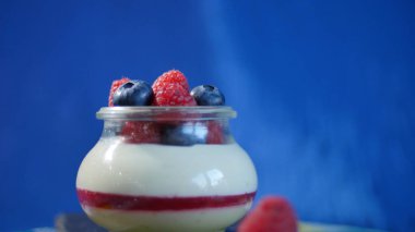 Ev yapımı yoğurt bir cam kavanoza yaban mersini ile. Çilekli yoğurt, yakın çekim.