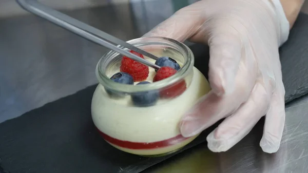 Domácí jogurt s borůvkami ve skleněné nádobce. Ruční zavedení jahoda v jogurtu, zblízka — Stock fotografie
