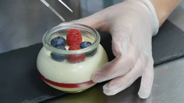 Domácí jogurt s borůvkami ve skleněné nádobce. Ruční uvedení jahoda v jogurtu — Stock fotografie