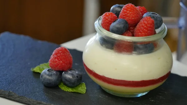 Domácí jogurt s borůvkami ve skleněné nádobce. krásně naaranžované bobule zdobí dezert, zblízka — Stock fotografie