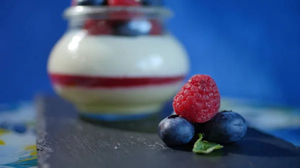 Hemgjord yoghurt med blåbär i en glasburk. Jordgubbar i yoghurt, närbild. — Stockfoto