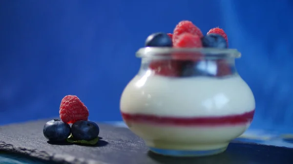 Hemgjord yoghurt med blåbär i en glasburk. Jordgubbar i yoghurt, närbild. — Stockfoto