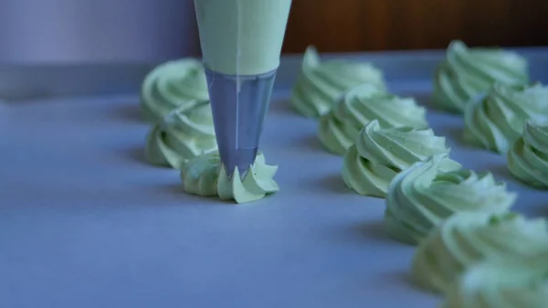 Squeeze the cream filling on the green cupcake, closeup — Stock Photo, Image