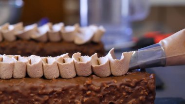 Bir pasta pişirme. Kek üzerine krema sıkma. Kek üzerine sıkılmış lezzetli lezzetli krem