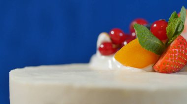 Beyaz krema ve şekerli meyveler ile geleneksel Noel meyveli kek. Kamkat, kızılcık, çilek, closeup ile kremalı pasta