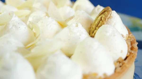 Closeup de chicotadas decoração bolo de creme. Delicioso bolo de creme branco decorado com ornamentos dourados — Fotografia de Stock