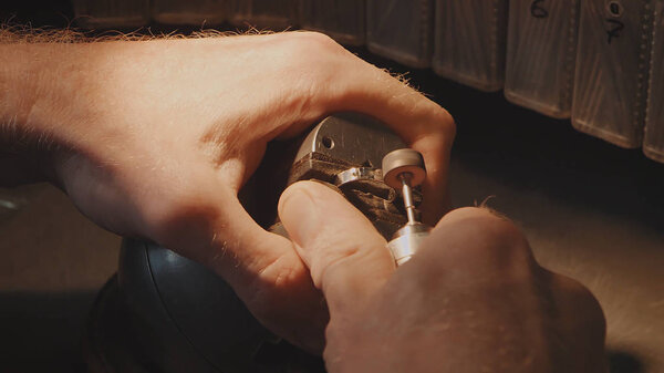 Production of rings. Jeweler working with wax model ring in his workshop. Craft jewelery making. Detail shot with low depth of field. Jeweler making handmade jewelry on vintage workbench. Craft of