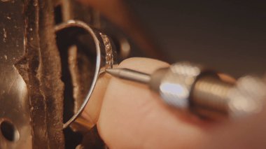 Kuyumcu bir değerli taş kuruyor. El sanatları takı yapımı. Tamir halka. Elmas yüzüğü koyarak. Makro video. İle profesyonel araçları yapımı craft mücevher. Elmas belirli bir konuma geçirme