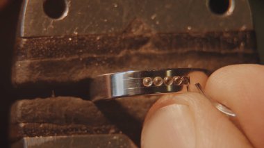 Kuyumcu bir değerli taş kuruyor. El sanatları takı yapımı. Tamir halka. Elmas yüzüğü koyarak. Makro video. İle profesyonel araçları yapımı craft mücevher. Elmas belirli bir konuma geçirme