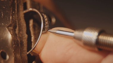 Kuyumcu bir değerli taş kuruyor. El sanatları takı yapımı. Tamir halka. Elmas yüzüğü koyarak. Makro video. İle profesyonel araçları yapımı craft mücevher. Elmas belirli bir konuma geçirme