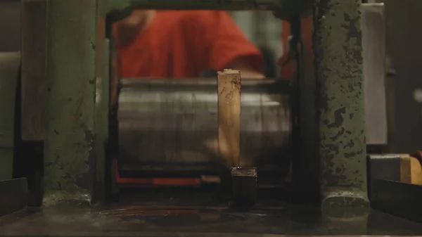 Χέρι έλασης ράβδους χρυσού. Εργοστάσιο εργαζόμενο επεξεργασία ρολό φύλλο χάλυβα. Βιομηχανία μετάλλων. Μηχάνημα για στρίψιμο χάλυβα φύλλο κυλώντας μύλων. Εφέ Tilt shift — Φωτογραφία Αρχείου
